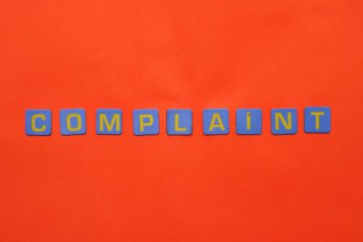 Complaint - in letter tiles on an orange background.