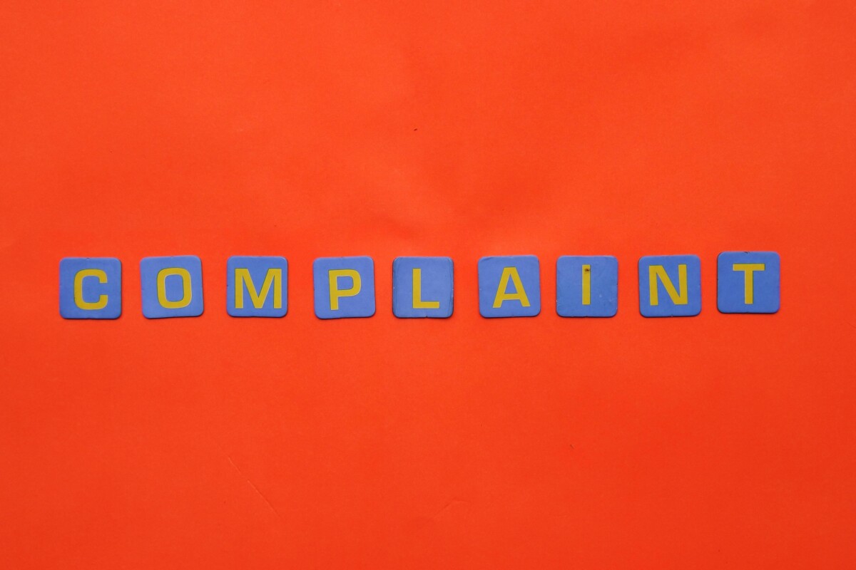 Complaint - in letter tiles on an orange background.