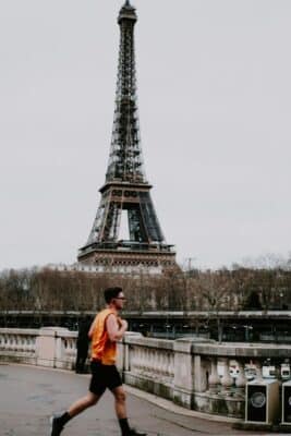 A runner runs past the Eiffel Tower.