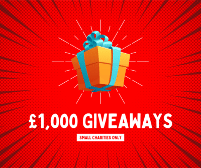 £1,000 giveaways, small charities only. A present wrapped with a blue bow on an exploding red background.