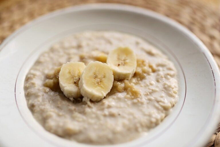 Bowl of porridge with chopped bananas in it.