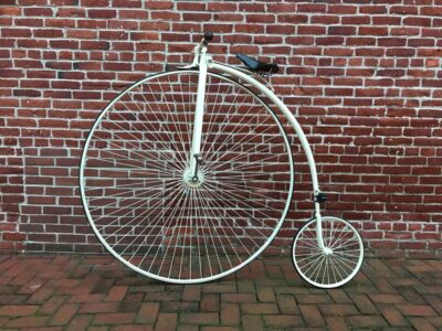 Penny farthing bicycle against a brick wall