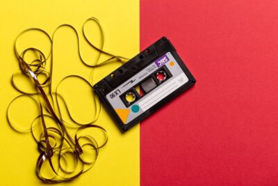 Tape cassette unspooled on yellow and red background - image: pexels.com