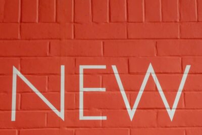 'NEW' sign in white paint on a terracotta brick wall. Photo: Nick Fewings on Unsplash.com
