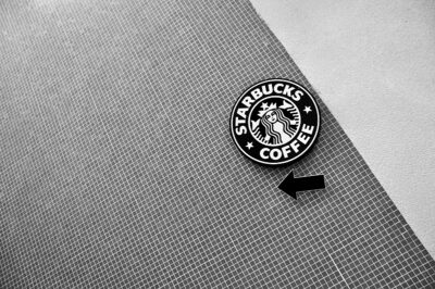 Starbucks logo on a wall. Black and white photo.