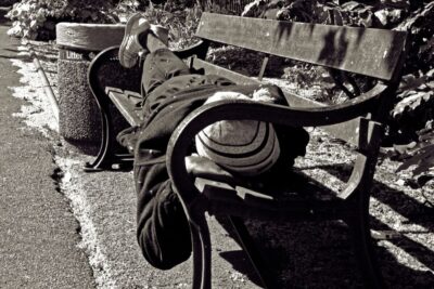 Homeless person on a bench. Black and white.