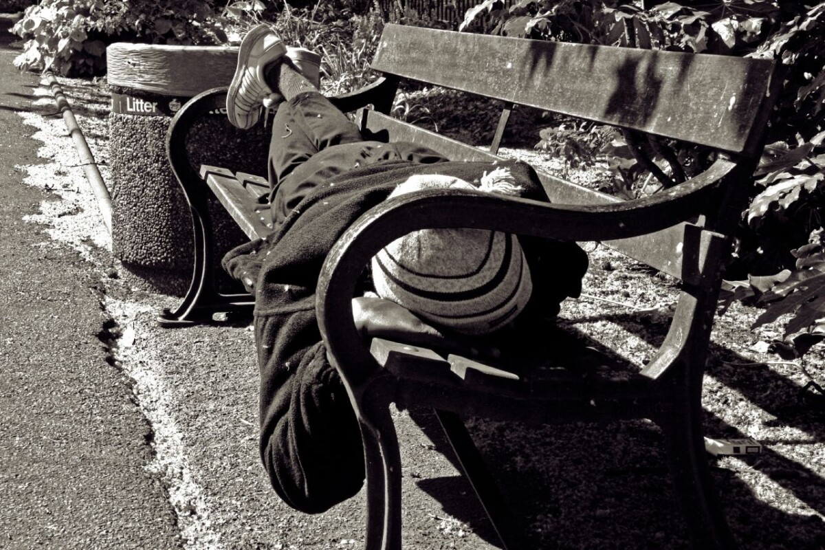 Homeless person on a bench. Black and white.