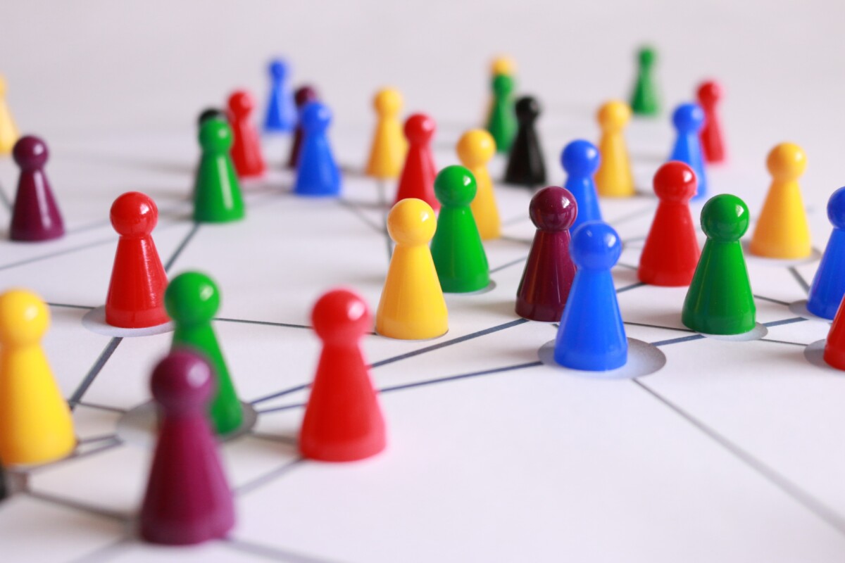 A network of people, illustrate by plastic people-shaped items on a paper base with lines linking them. Photo: Pixabay/Pexels.com