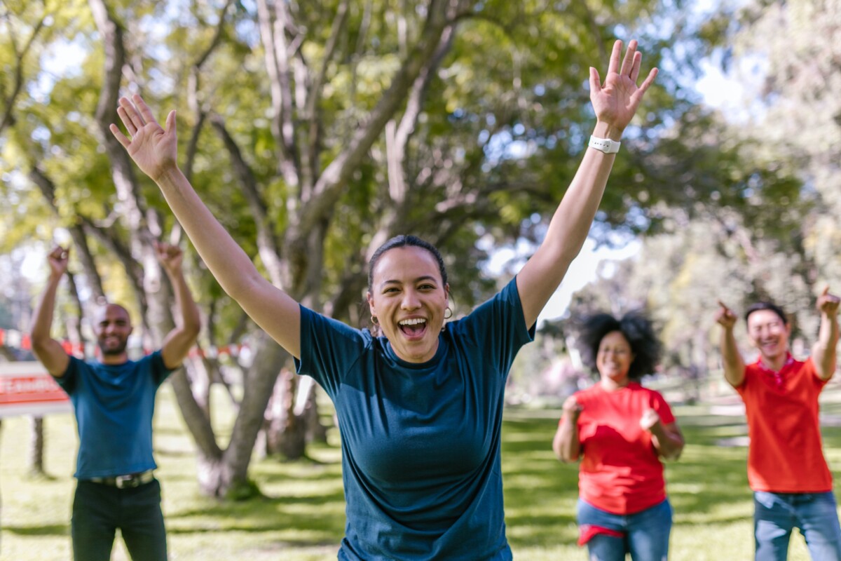 Three people cheer a happy winner, running in a park. Photo: Rodnae Productions on Pexels.com