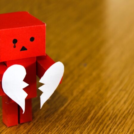 Red cardboard robot holds white broken heart - photo: Pexels.com