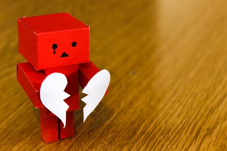 Red cardboard robot holds white broken heart - photo: Pexels.com
