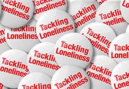 Red and white 'tackling loneliness' buttons. Image: British Red Cross
