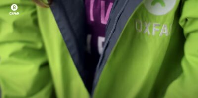 Oxfam street fundraiser bright green jacket. Still from Oxfam GB video.