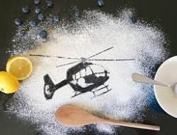 Outline image of a helicopter on a board covered in flour.
