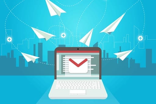 Emails flying like paper aeroplanes from a laptop