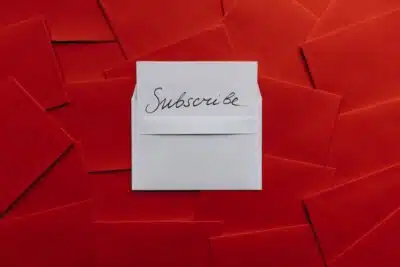 Subscribe - text on a white envelope, on a background of red envelopes.