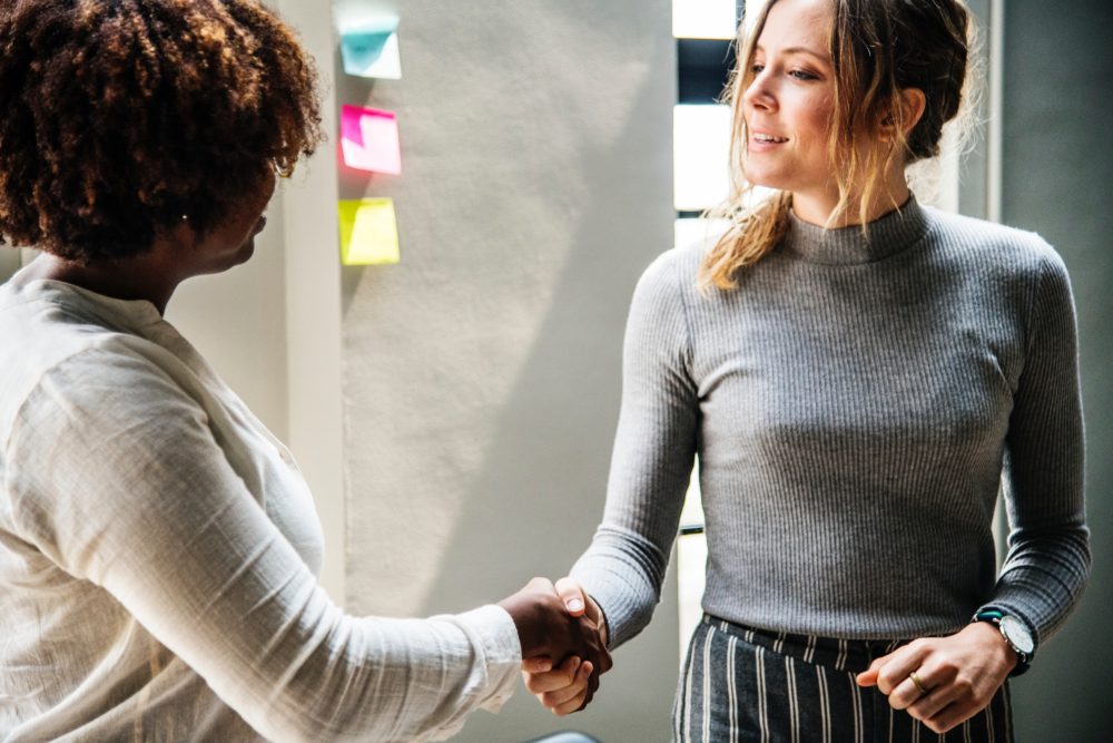 Two women shaking hands in business deal - photo: Pexels.com