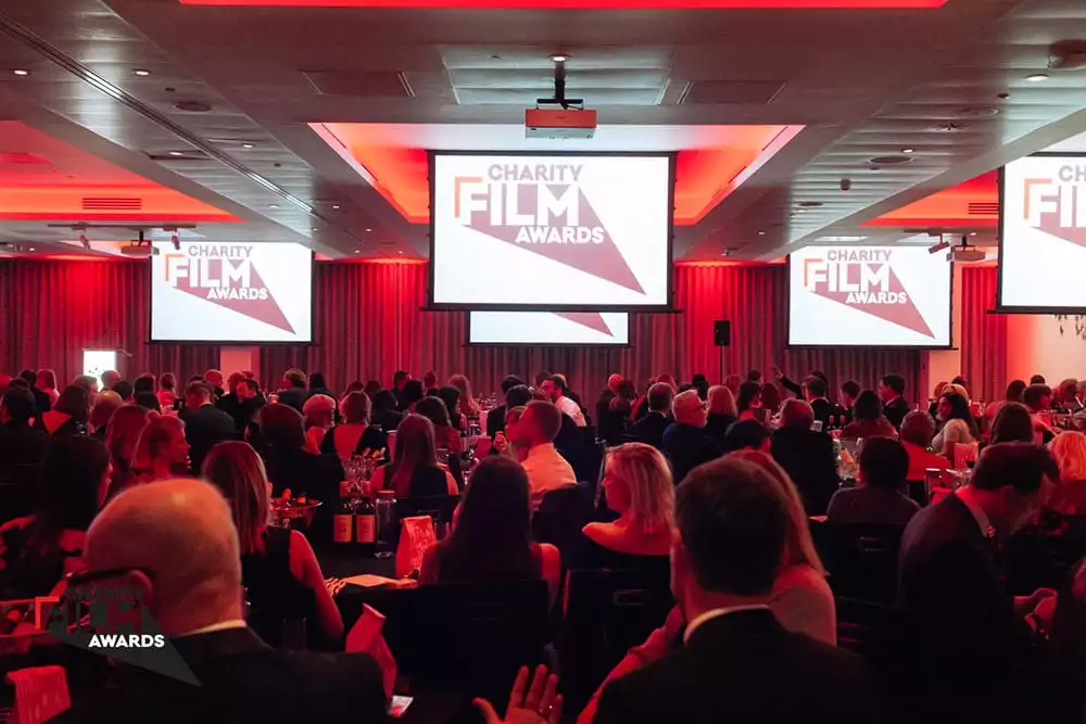 Guests at the Charity Film Awards 2019, with large screens on which to view the winning entries