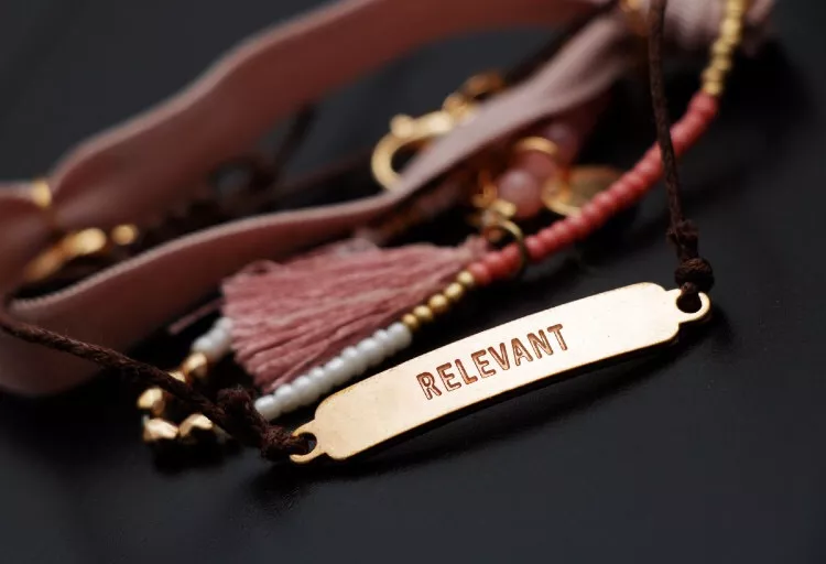 Gold bracelet with 'relevance' engraved on it
