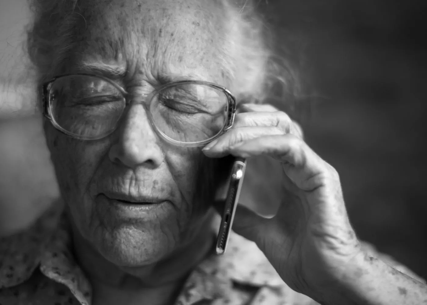Adult with glasses listening on the phone