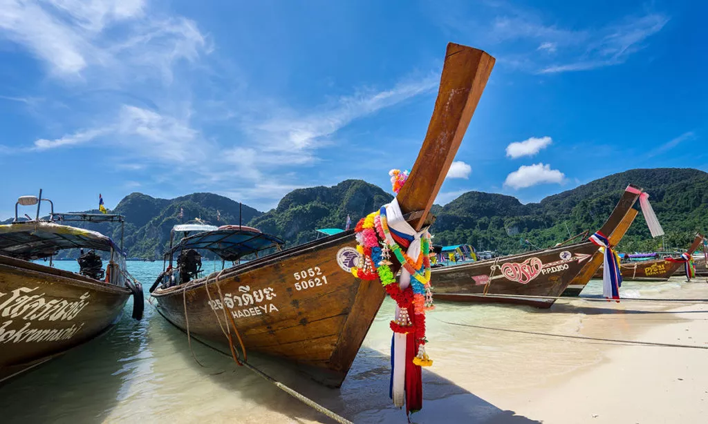 Decorated boats on the shore of an island in the sun. Photo: Unsplash