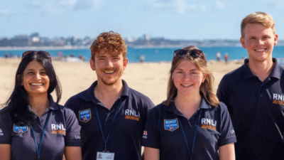 Four RNLI face to face fundraisers on a beach in summer 2019.