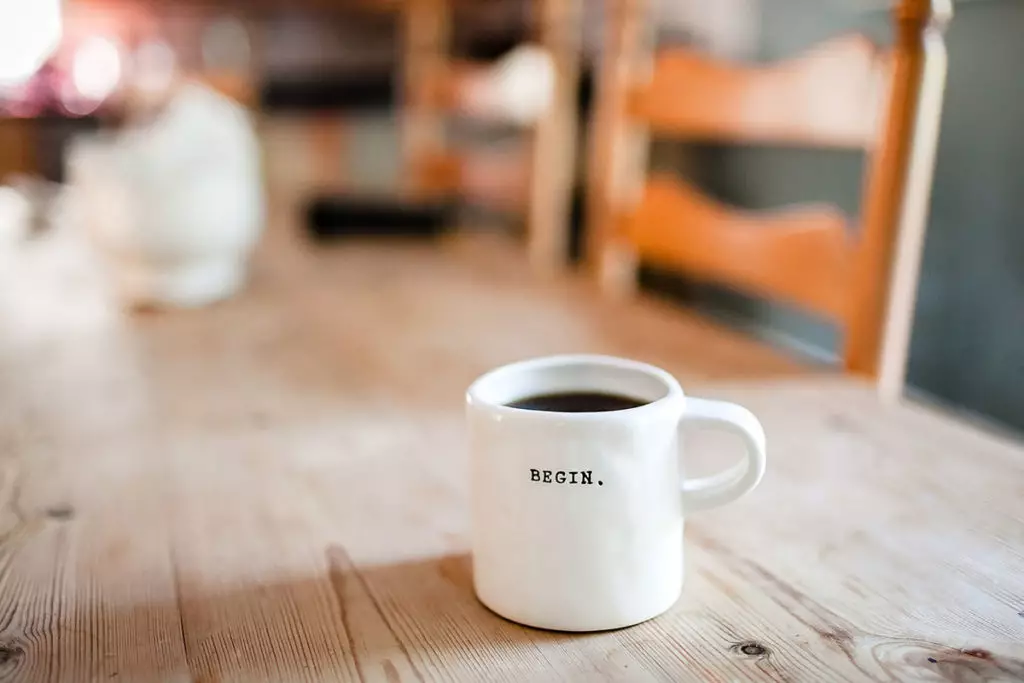 Begin sign on coffee mug on a table - photo: Unsplash