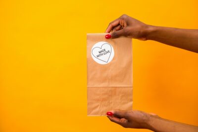 Paper shopping bag with 'made with love' sticker on it. Photo: Pexels