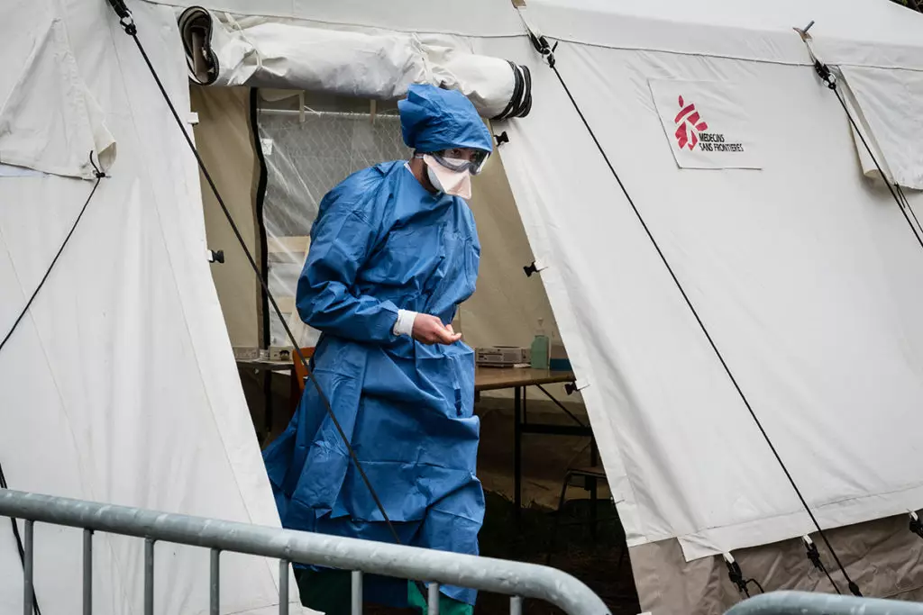 MSF doctor in mask leaves a tent