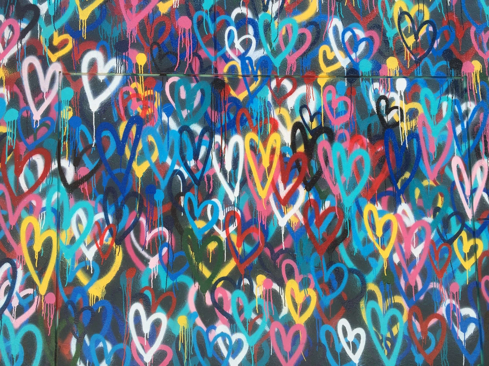 Multi-coloured love hearts - graffiti on a wall - photo: Unsplash