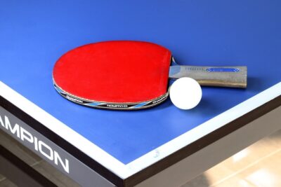 Table tennis bat and ball on a blue table - Pixabay