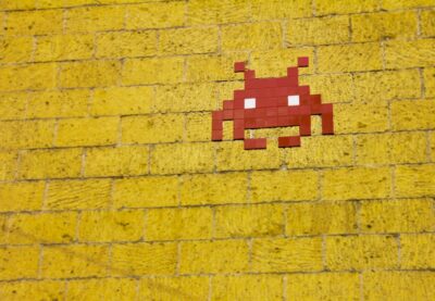 Space Invaders icon on a yellow wall - photo: Pexels.com