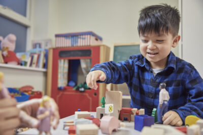 A young boy plays with wooden building blocks. Photo: NPSCC