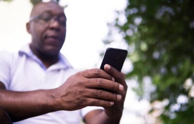 Middle-aged Black man looks at his mobile phone by Joshua Woroniecki from Pixabay