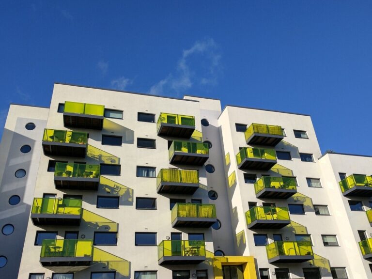 a block of flats with colourful yellow balconies by MobyMotion from Pixabay