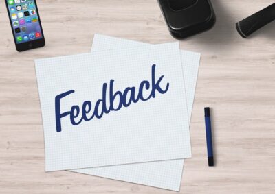 sheets of paper on a desk with a pen and a phone, saying feedback. by Dirk Wouters from Pixabay