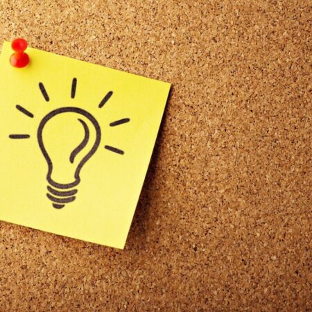 A yellow post-it with a lightbulb drawing on it, on a cork notice board by Gino Crescoli from Pixabay