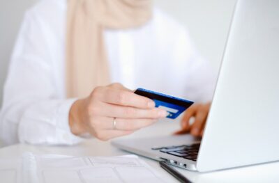 A woman holding her credit card to make a payment on her laptop by Anna Shvets from Pexels