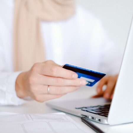 A woman holding her credit card to make a payment on her laptop by Anna Shvets from Pexels
