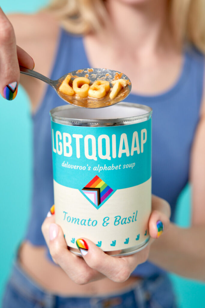 LGBT pasta shapes being held above a Deliveroo can of soup