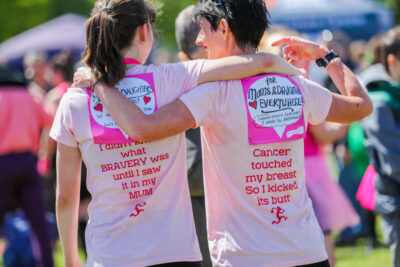 Mother and daughter participants in CRUK Race for Life, with messages on the back of their tshirts