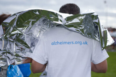 Runner for Alzheimers Society under a foil cape