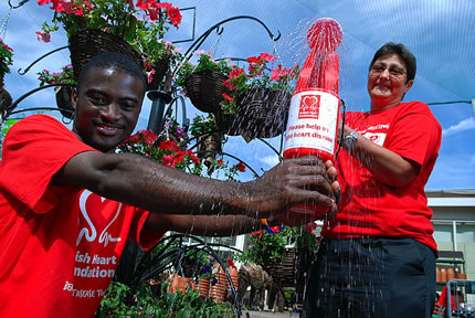 British Heart Foundation supporters at Home Retail Group water a collecting tin with a watering can!