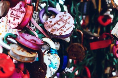 Many coloured locks with love hearts and loving engravings on them, all on a chain link fence. Photo: Unsplash