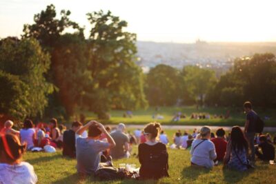 People sitting in a park in the sun. Photo: Pexels