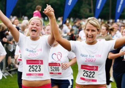 Women hold hands at end of Race for Life. Photo copyright: onEdition