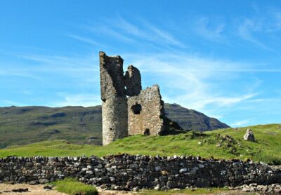 The ruins of Ardvreck castle surrounded by grass and a blue sky. Photo: Pixabay.com