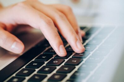 a hand typing on a lapboard keyboard. Photo: Pixabay