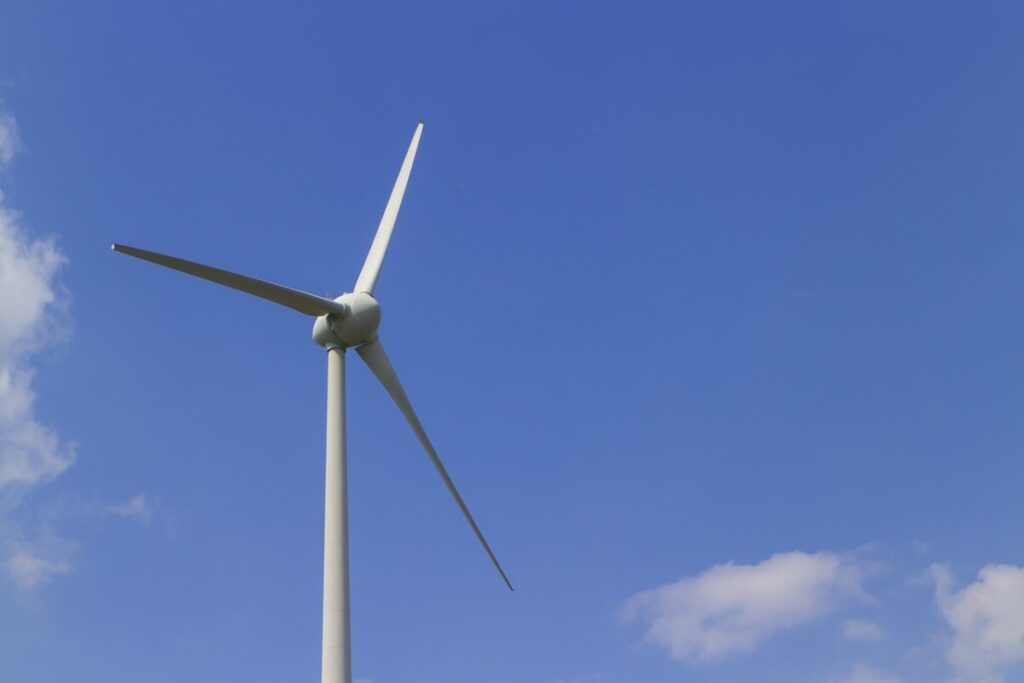 Wind turbine against a blue sky. Photo: Pixabay