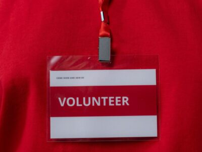 A red volunteer badge on a lanyard